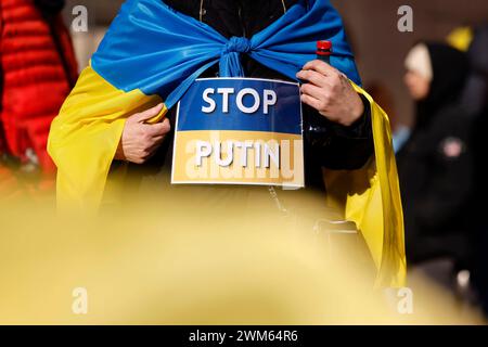 Eine Demonstrantin hält ein Schild mit der Aufschrift Stop Putin . Demonstranten schwenken Ukraine-Flaggen. Bei einer Großkundgebung auf dem Roncalliplatz demonstrieren Menschen anlässlich des Jahrestags des russischen Angriffskriegs auf die Ukraine für mehr Unterstützung für die Ukraine. Viele der Demonstranten fordern mehr Waffenlieferungen und eine Intervention der NATO in den Konflikt. Köln, 24.02.2024 NRW Deutschland *** Ein Demonstrant hält ein Schild mit der Aufschrift Stop Putin Demonstranten schwenken ukrainische Fahnen bei einer großen Kundgebung auf dem Roncalliplatz demonstrieren Menschen für mehr Unterstützung für die Ukraine Stockfoto