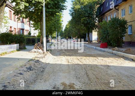 Feldweg mit entferntem Asphalt in der Stadt. Baureparaturstelle für Straßenbauarbeiten. Stockfoto