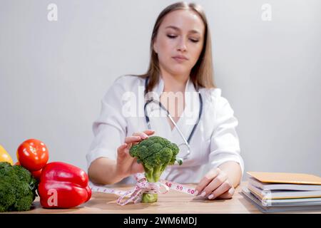 Professionelle Ernährungsberaterin mit Blick auf Obst und Gemüse bei der Konsultation des Patienten. Stockfoto