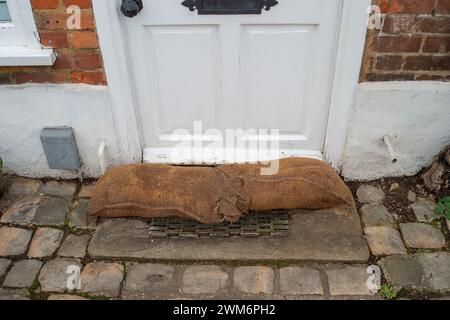 Chalfont St Giles, Großbritannien. Februar 2024. Sandsäcke vor einer Hütte. Überflutungen sind im Dorf Chalfont St Giles in Buckinghamshire zu finden. Obwohl die Felder und das Stadtzentrum anfällig für Hochwasser sind, glauben einige Anwohner laut sozialen Medien, dass das anhaltende Ausmaß der Überschwemmung auf den HS2-Tunnel in den Kreideflächen für die High Speed Rail Chiltern-Tunnel zurückzuführen sein könnte, der Wasser verdrängt. Quelle: Maureen McLean/Alamy Live News Stockfoto