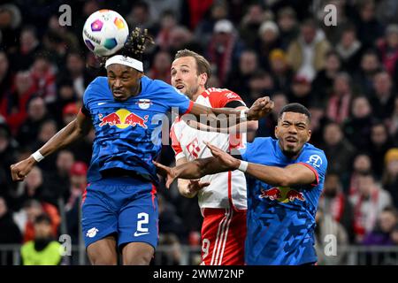 München, Deutschland. Februar 2024. Fußball: Bundesliga, Bayern München - RB Leipzig, Spieltag 23, Allianz Arena. Der Leipziger Mohamed Simakan (l) führt den Ball aus der Gefahrenzone vor dem Münchner Harry Kane (M) und dem Leipziger Benjamin Henrichs. Quelle: Sven Hoppe/dpa/Alamy Live News Stockfoto