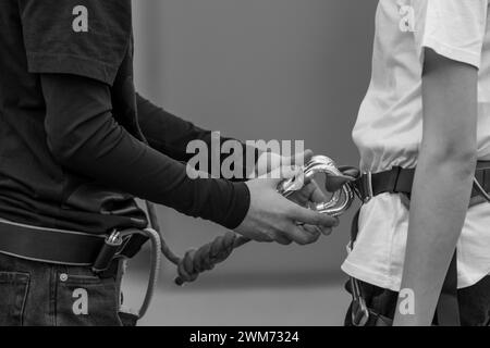 Sicherheitsberater. Zwei junge Jungen schnallen sich für Abenteuer an. Sicherheitsüberprüfungen des Kabelbaums. Schwarzweiß, Schwarzweiß. Stockfoto