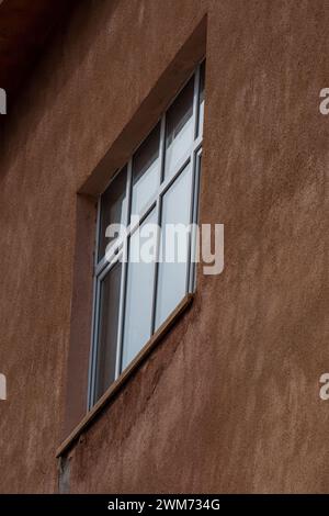 Entdecken Sie die Eleganz der schrägen Fensterrahmen. Reflexion im Architekturdesign. Wandfassade. Stockfoto