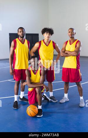 Ein vielseitiges Basketballteam posiert selbstbewusst auf dem Platz Stockfoto