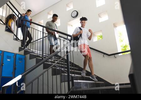 Teenager-Biracial-Jungen und Teenager-Mädchen in einer Highschool-Treppe Stockfoto