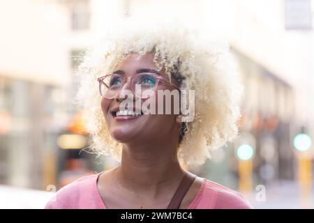 Die junge Frau lächelt hell in der Stadt Stockfoto