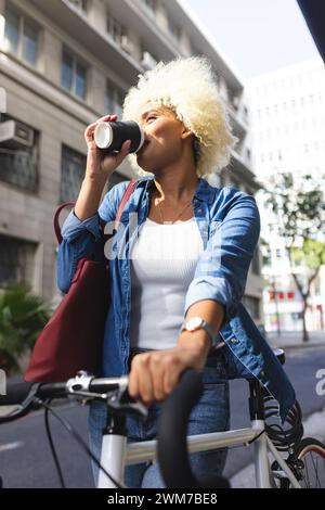 Die junge Frau trinkt Kaffee im Freien in der Stadt Stockfoto