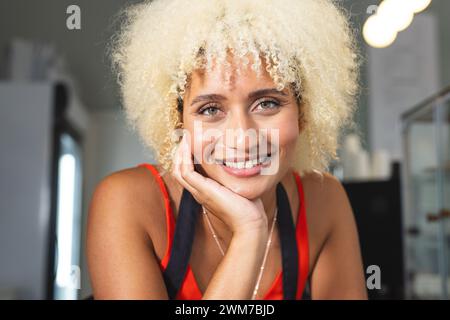 Eine junge Barista, weibliche Café-Besitzerin, lächelt warm in die Kamera Stockfoto