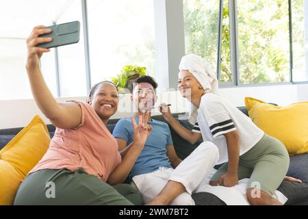 Ein junger asiatischer Mann und zwei rassistische Frauen machen zu Hause ein Selfie Stockfoto