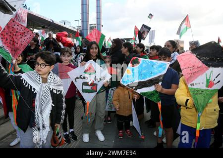 Salford, Großbritannien. Februar 2024. Hunderte von Familien versammeln sich mit ihren Kindern, um gegen die BBC und ihre "voreingenommene" Berichterstattung über die Bombardierung Palästinas zu protestieren. Die Demonstranten forderten ein freies Palästina und einen Waffenstillstand. Die Kinder hielten Drachen in Solidarität mit den Kindern im Gazastreifen auf, die das guiness-Buch der Rekorde für die meisten gleichzeitig geflogenen Drachen halten. Die Kinder verbanden auch Puppen und stellten Plakate zusammen, die einen Haufen Kinderschuhe hinterließen, um die Kinder zu repräsentieren, die in Gaza getötet wurden. Media City, Salford, Großbritannien. Quelle: Barbara Cook/Alamy Live News Stockfoto