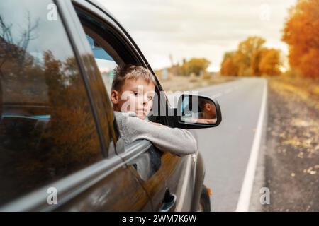 Junge, der seine Köpfe und Hände aus dem Auto nimmt Stockfoto