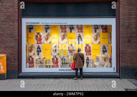 Frau, die Iittalas neue Marke und das neue Logo im Schaufenster des Kaufhauses Stockmann im Bezirk Kluuvi in Helsinki, Finnland, ansieht Stockfoto