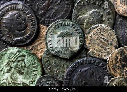 Antike römische Münzen mit Kaiserporträts aus nächster Nähe, Stapel von altem Metallgeld, Blick von oben auf den Hintergrund mit Vintage-Muster. Konzept von Rom, Reich, Textur Stockfoto