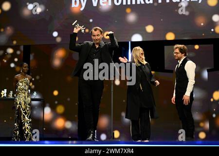 Berlin, Deutschland. Februar 2024. Martin Gschlacht (2. Von links) steht während der Preisverleihung bei der Abschlussgala im Berlinale Palast auf der Bühne, nachdem er für seine Kameraarbeit im Film „das Teufelsbad“ einen Silbernen Bären in der Kategorie herausragende künstlerische Leistungen gewonnen hat. Die 74. Internationalen Filmfestspiele Berlin finden vom 15. Bis 25. Februar 2024 statt. Quelle: Monika Skolimowska/dpa/Alamy Live News Stockfoto