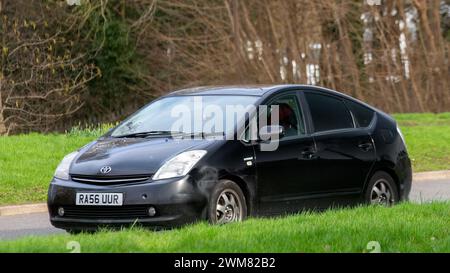 Milton Keynes, UK-Feb 24th 2024: 2007 schwarzes Toyota Prius Hybrid-Elektroauto, das auf einer englischen Straße fährt Stockfoto