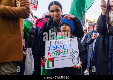 Bradford, Großbritannien. FEBRUAR 2024. Ein kleines Kind mit superman-Hut hält ein Plakat mit der Aufschrift, die israelische Apartheid zu beenden, am Centenary Square in Bradford. Credit Milo Chandler/Alamy Live News Stockfoto