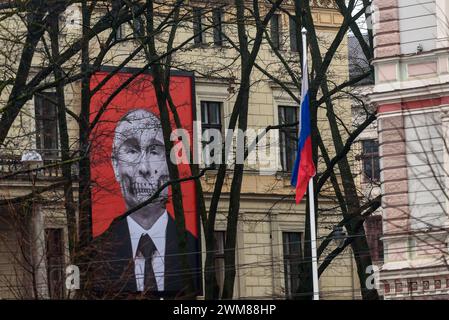 RIGA, LETTLAND. Februar 2024. Foto mit selektivem Fokus. Großes Banner mit Kunstwerken - Schädel des russischen Präsidenten Wladimir Putin vor der russischen Botschaft in Lettland. Zwei Jahre, seit Russland einen brutalen Krieg gegen die Ukraine begonnen hat. Stockfoto