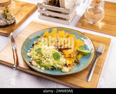 Köstliches Weiner Schnitzel mit Eisbergsalat auf dem Restauranttisch, Menükonzept Stockfoto