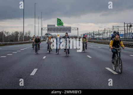 Amsterdam, Nordholland, Niederlande. Februar 2024. Aktivisten auf dem Fahrrad schließen sich anderen Aktivisten an, die die Autobahn A10 blockieren. Am 24. Februar 2024 blockierten Aktivisten die A10, eine Hauptstraße in Amsterdam, Niederlande. Ihre Forderung lautete, dass die ING Bank ihre Investitionen in die fossile Brennstoffindustrie einstellen sollte. (Kreditbild: © James Petermeier/ZUMA Press Wire) NUR REDAKTIONELLE VERWENDUNG! Nicht für kommerzielle ZWECKE! Stockfoto