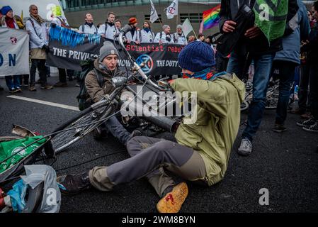 Amsterdam, Nordholland, Niederlande. Februar 2024. Aktivisten sperren sich zusammen und an ein Fahrrad, um sich selbst zu verhaften. Am 24. Februar 2024 blockierten Aktivisten die A10, eine Hauptstraße in Amsterdam, Niederlande. Ihre Forderung lautete, dass die ING Bank ihre Investitionen in die fossile Brennstoffindustrie einstellen sollte. (Kreditbild: © James Petermeier/ZUMA Press Wire) NUR REDAKTIONELLE VERWENDUNG! Nicht für kommerzielle ZWECKE! Stockfoto