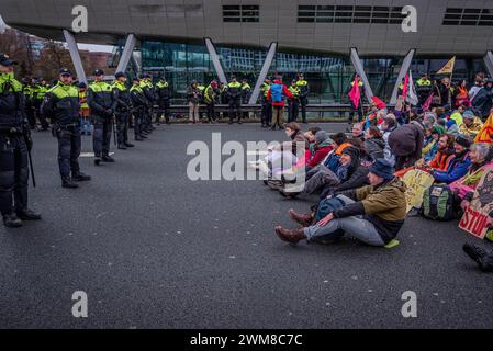 Amsterdam, Nordholland, Niederlande. Februar 2024. Die niederländische Polizei umgibt eine Gruppe von Aktivisten, die die Autobahn A10 blockieren. Am 24. Februar 2024 blockierten Aktivisten die A10, eine Hauptstraße in Amsterdam, Niederlande. Ihre Forderung lautete, dass die ING Bank ihre Investitionen in die fossile Brennstoffindustrie einstellen sollte. (Kreditbild: © James Petermeier/ZUMA Press Wire) NUR REDAKTIONELLE VERWENDUNG! Nicht für kommerzielle ZWECKE! Stockfoto