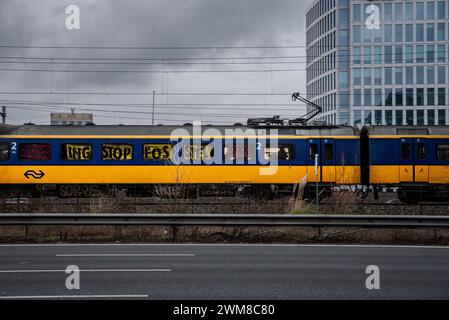 Amsterdam, Nordholland, Niederlande. Februar 2024. Aktivisten bedeckten öffentliche Bahnfenster mit Prominenz-Aufruhr-Bannern. Am 24. Februar 2024 blockierten Aktivisten die A10, eine Hauptstraße in Amsterdam, Niederlande. Ihre Forderung lautete, dass die ING Bank ihre Investitionen in die fossile Brennstoffindustrie einstellen sollte. (Kreditbild: © James Petermeier/ZUMA Press Wire) NUR REDAKTIONELLE VERWENDUNG! Nicht für kommerzielle ZWECKE! Stockfoto