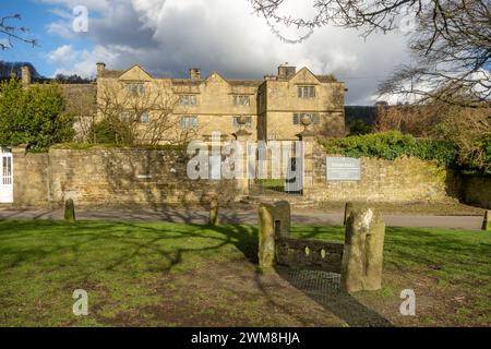 Eyam Hall, ein Herrenhaus im JakoBean-Stil im Pestdorf Eyam England im Derbyshire Peak District, von den Beständen auf dem Dorfgrün aus gesehen Stockfoto