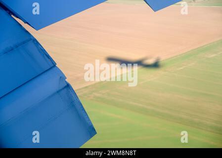 Blick auf die Flügelklappe vom Fenstersitz bei Air France/KLM mit Schatten auf dem Jet über Ackerland in Frankreich, in der Nähe des Flughafens Charles de Gaulle Stockfoto