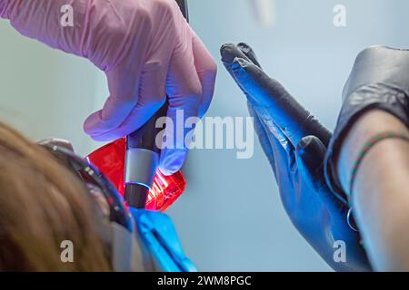 Glänzen Sie eine UV-Lampe während der Zahnbehandlung. Pflege und Pflege der Zähne Stockfoto