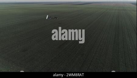 Filmcrew, die eine Szene im Schnittfeld aufbaut. Trübe Winter-Drohnenaufnahme. Stockfoto