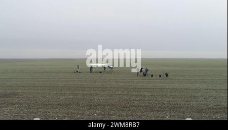 Filmcrew, die eine Szene im Schnittfeld aufbaut. Trübe Winter-Drohnenaufnahme. Stockfoto