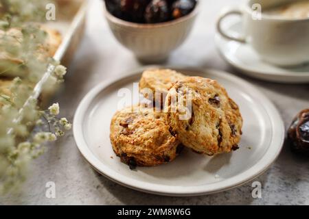 Hausgemachte Dattelscones serviert mit einer Tasse Kaffee und frischem Dattelobst Stockfoto