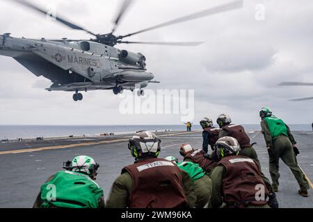 PAZIFIK (16. Februar 2024) Marines, die der 31st Marine Expeditionary Unit (MEU) zugewiesen sind, beobachten einen Super Hallion Helikopter CH-53E vom Air Combat Element (ACE) der 31st Marine Expeditionary Unit (MEU) und starten vom vorwärtsgerichteten amphibischen Angriffsträger USS America (LHA 6). während der Durchführung des Flugbetriebs im Pazifischen Ozean, 16. Februar. America, Leitschiff der America Amphibious Ready Group, ist im Einsatzgebiet der 7. US-Flotte im Einsatz. Die 7. US-Flotte ist die größte nach vorne gerichtete nummerierte Flotte der US Navy und interagiert routinemäßig mit allie Stockfoto