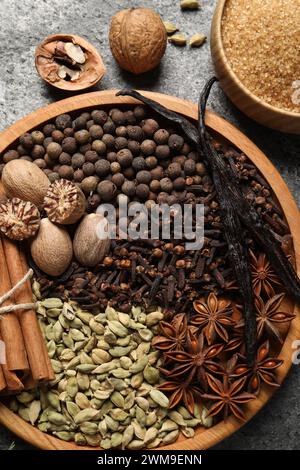 Verschiedene Gewürze und Nüsse auf grauem Tisch, flach gelegen Stockfoto