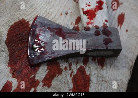 Axt mit Blut auf Holzoberfläche, Nahaufnahme Stockfoto