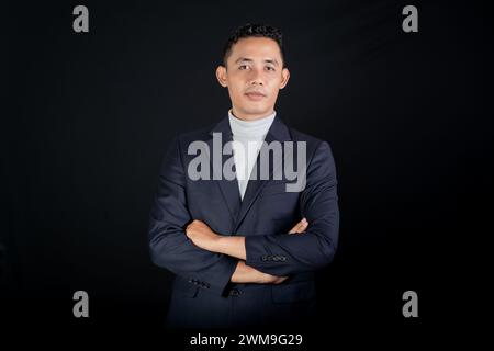 Porträt eines schönen eleganten Mannes in schwarzem Anzug auf schwarzem Hintergrund. Studio-Modus Hochformat Stockfoto