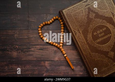 Islamisches heiliges Buch Koran auf Holztischhintergrund mit Tasbih. Ramadan kareem/Eid Mubarak Konzept Stockfoto