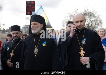 London, Großbritannien. Februar 2024. Priester aus orthodoxen Kirchen in London werden während der Kundgebung mit den Demonstranten zum Trafalgar Square marschiert. Die Ukrainer und ihre Unterstützer versammelten sich in Marble Arch und marschierten zum Trafalgar Square in London am 2. Jahrestag des andauernden russisch-ukrainischen Krieges. Sie fordern die britische Regierung auf, mehr Waffen an die Ukraine zu liefern, da sich der Krieg nun auf das dritte Jahr hingezogen hat. (Foto: Hesther ng/SOPA Images/SIPA USA) Credit: SIPA USA/Alamy Live News Stockfoto