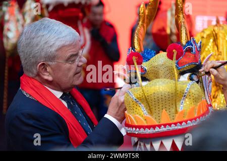 Den Haag, Niederlande. Februar 2024. Jan van Zanen, Bürgermeister von den Haag, verleiht einem Drachen den letzten Schliff während einer Tempelmesse, um das Laternenfest im Atrium City Hall in den Haag, Niederlande, am 24. Februar 2024 zu feiern. Quelle: Meng Dingbo/Xinhua/Alamy Live News Stockfoto