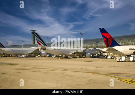 Kommerzielle Jets von Air France und Delta Airlines an den Eingangstoren, die Passagiere und Gepäck am Flughafen Charles de Gaulle, Paris, Frankreich, verladen Stockfoto