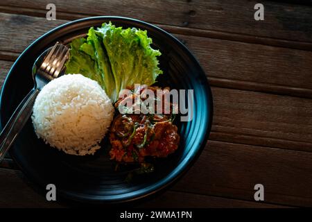 Gebratenes Rindfleisch mit Basilikum, gehacktem Chili und Knoblauch, serviert mit Dampfreis. Stockfoto