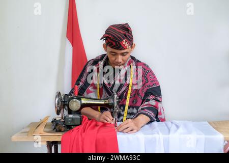 Der Schneider macht die indonesische Nationalflagge vor dem Unabhängigkeitstag Stockfoto