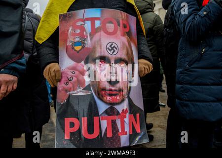 Vilnius, Litauen. Februar 2024. Der Demonstrant hält ein Plakat mit dem russischen Präsidenten Wladimir Putin während einer Kundgebung zur Unterstützung der Ukraine. Am zweiten Jahrestag der russischen Invasion fanden in Vilnius ein marsch und eine Demonstration zur Unterstützung der Ukraine statt, an der etwa 1.000 Menschen teilnahmen. Quelle: SOPA Images Limited/Alamy Live News Stockfoto