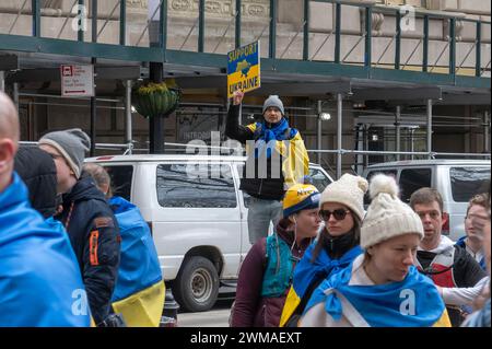 Ein Mann hält ein Plakat bei einer Flaggenwahnungszeremonie für die Ukraine am zweiten Jahrestag der russischen Invasion in die Ukraine im historischen Bowling Green Park in Lower Manhattan. Der unnachgiebige Krieg Russlands gegen die Ukraine hat in seinem dritten Jahr Bedenken darüber geweckt, wie lange die westlichen Länder Kiew weiterhin Waffen und andere Unterstützung bereitstellen werden. Die Versorgung mit Munition, Waffen und Arbeitskräften ist heute ein entscheidender Faktor in einem Konflikt, der über eine halbe Million Opfer gefordert hat und die weit verbreitete Vertreibung von Zivilisten verursacht hat. (Foto: Ron Adar/SOPA Images/SIPA USA) Stockfoto