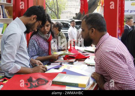 Dhaka, Bangladesch. Februar 2024. Man wählt Bücher an einem Stand einer Buchmesse in Dhaka, Bangladesch, 23. Februar 2024. Auf der jährlichen Buchmesse wurden etwa 900 Stände aufgestellt. Quelle: Sun Nan/Xinhua/Alamy Live News Stockfoto