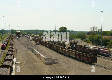 Lyon, Frankreich - 16. Mai 2023: Mehrere Reihen von Güterzügen werden auf einem weitläufigen Bahnhofsgelände mit verschiedenen Gütern beladen. Der Tag ist klar und sonnig, Show Stockfoto