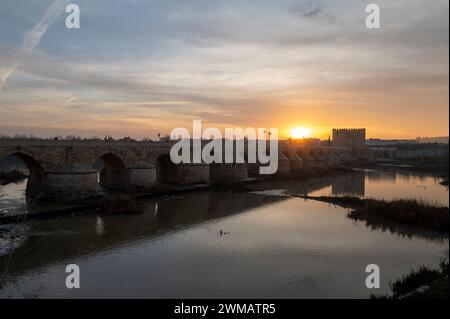 Bei Sonnenaufgang über der Römischen Brücke von Cordoba in Andalusien, Südspanien, ist eine lange restaurierte Fußgängerbrücke mit ursprünglich errichteten Bögen Stockfoto