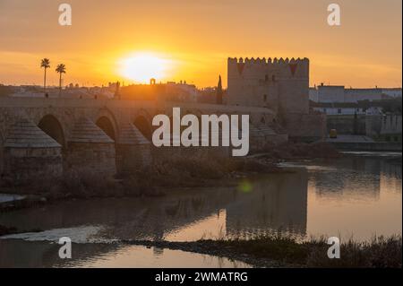 Bei Sonnenaufgang über der Römischen Brücke von Cordoba in Andalusien, Südspanien, ist eine lange restaurierte Fußgängerbrücke mit ursprünglich errichteten Bögen Stockfoto