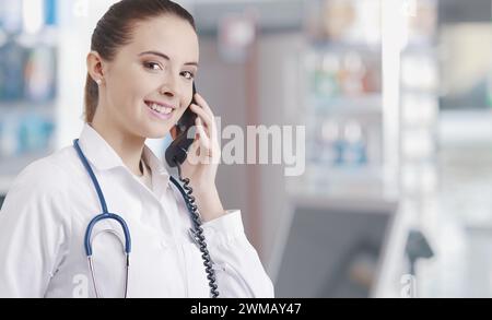 Sie arbeitet in der Apotheke, telefoniert und gibt Ratschläge Stockfoto