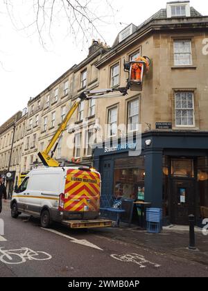 Arbeiter, die eine neue Wandbeleuchtung über der Boston Tea Party am Kingsmead Square, Bath, Somerset, mit einem Kirschpflücker am Van installieren. Stockfoto